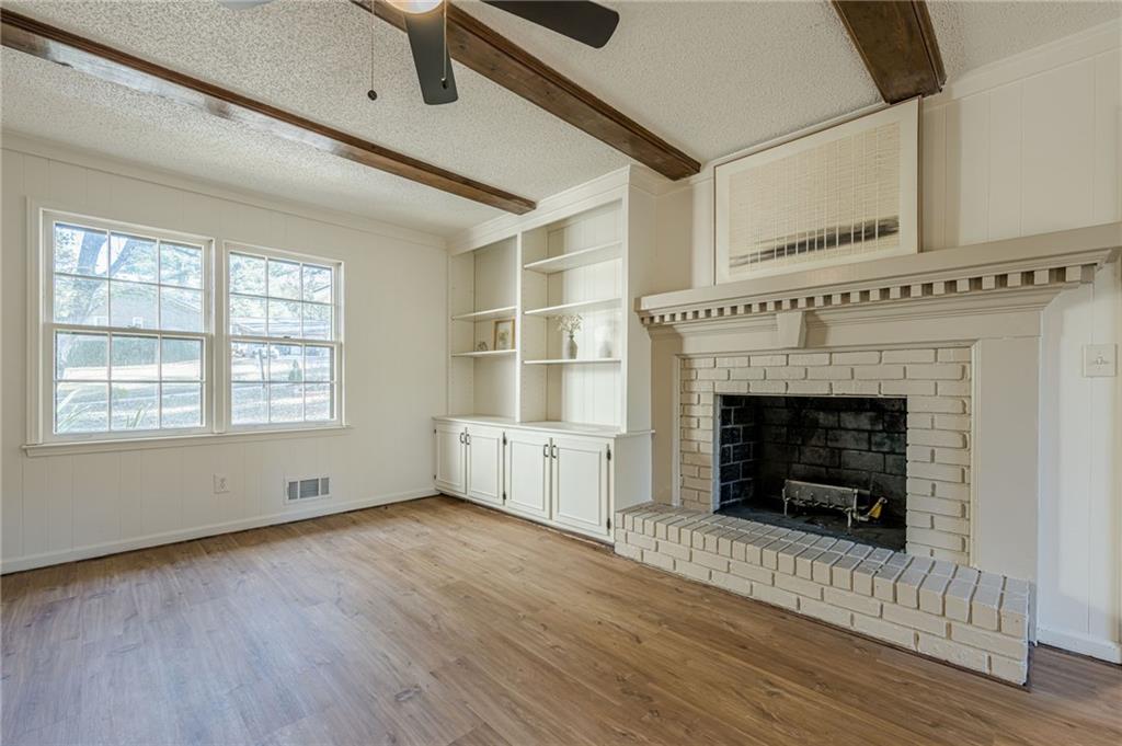 4147 Scofield Place Stone Mountain, GA 30083 - Photo 27 of 56 a view of an empty room with wooden floor fireplace and a window