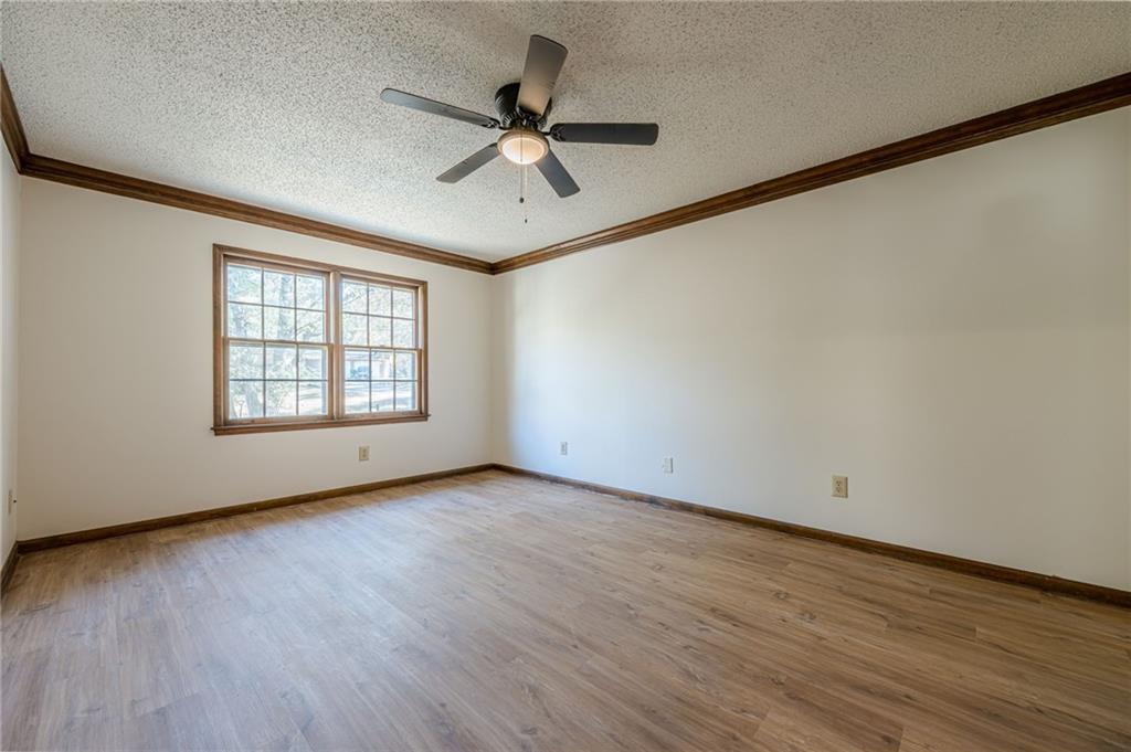 4147 Scofield Place Stone Mountain, GA 30083 - Photo 34 of 56 an empty room with wooden floor fan and windows