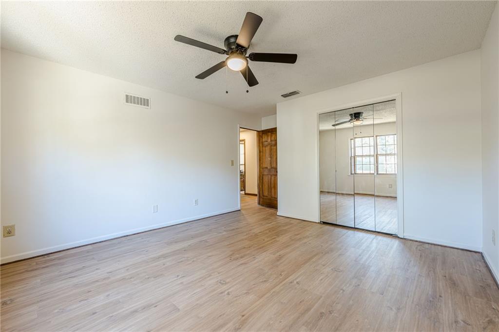 4147 Scofield Place Stone Mountain, GA 30083 - Photo 46 of 56 an empty room with wooden floor and windows