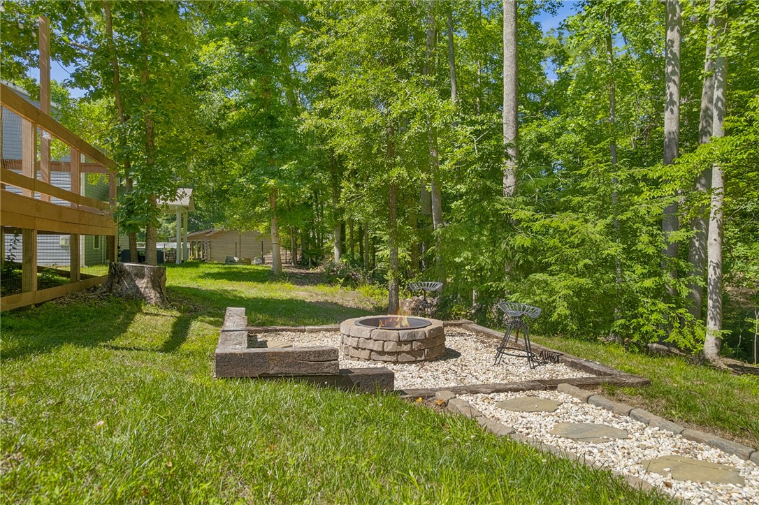 430 Johnson Road Central, SC 29630 - Photo 27 of 36 An inviting backyard fire pit area is nestled in a lush, green natural setting.