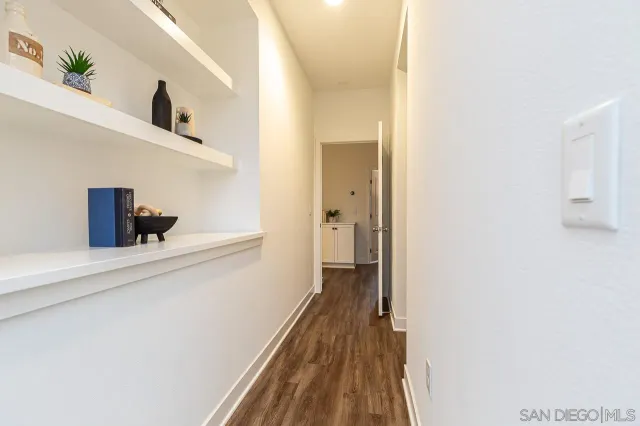 a hallway with wooden floor cabinet and entryway