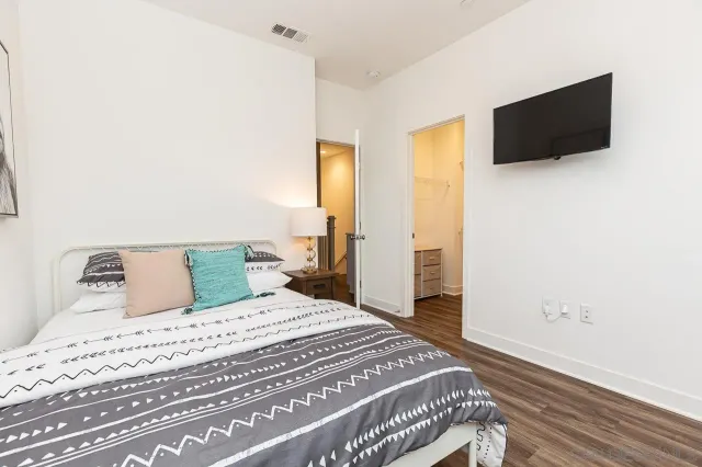 a bedroom with a bed and a flat screen tv