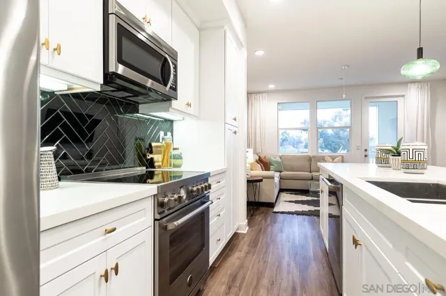 a kitchen with a sink a stove and cabinets