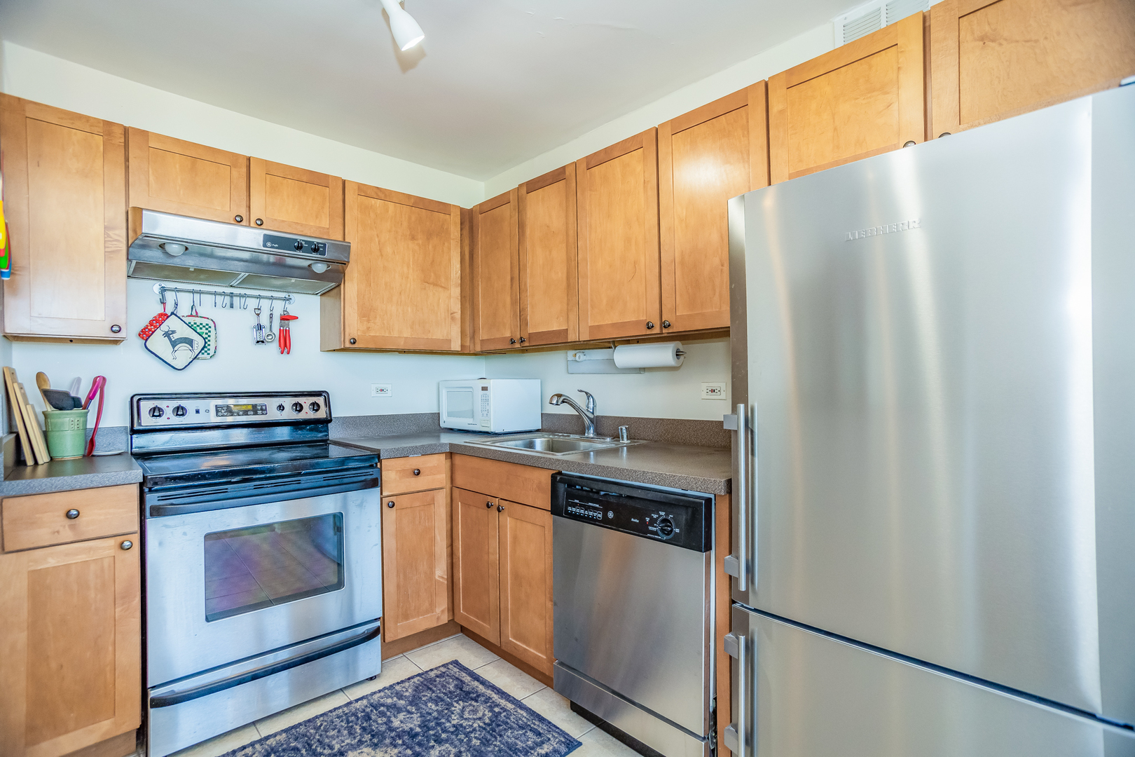 655 West Irving Park Road, Unit 3012 Chicago, IL 60613 - Photo 7 of 24 a kitchen with stainless steel appliances granite countertop a stove a refrigerator and a microwave