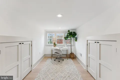 a work room with furniture a rug and a potted plant