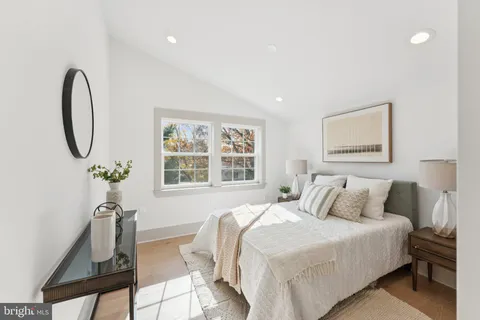 a bedroom with a bed a mirror and a window