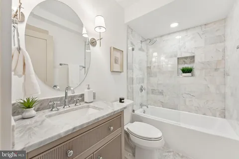 a bathroom with a granite countertop sink a toilet and a bathtub
