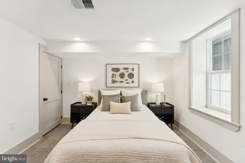 a bedroom with a bed and a large window