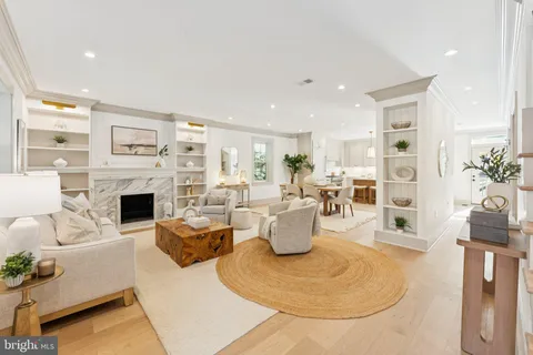 a living room with furniture a fireplace and a kitchen view