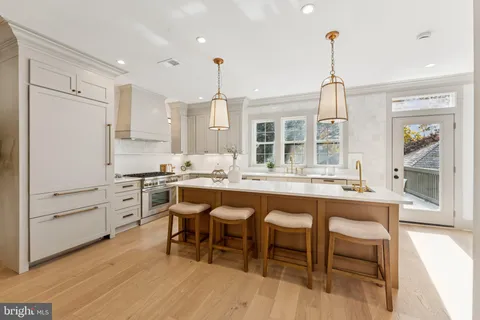 a kitchen with appliances cabinets and chair