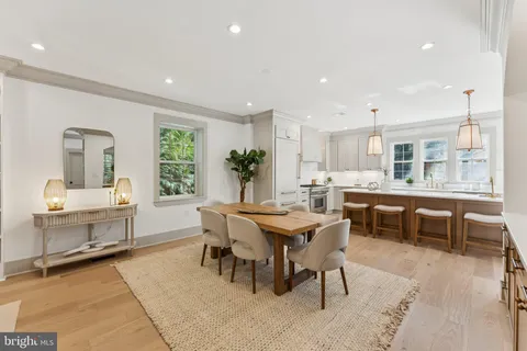 a dining area with a table chairs and a kitchen view