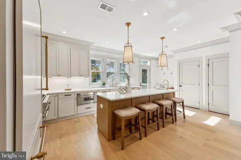 a large kitchen with cabinets chairs and counter space