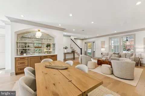 a living room with furniture a large window and wooden floor