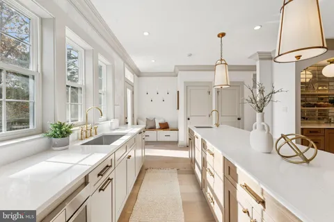 a large white kitchen with a large window and stainless steel appliances