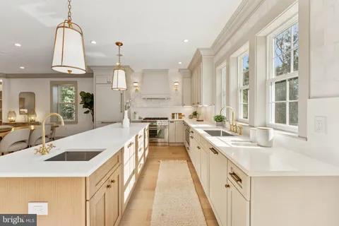 a large kitchen with kitchen island a stove a sink a center island and windows