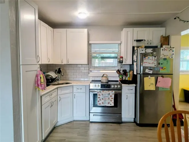 a kitchen with stainless steel appliances granite countertop a refrigerator sink and stove