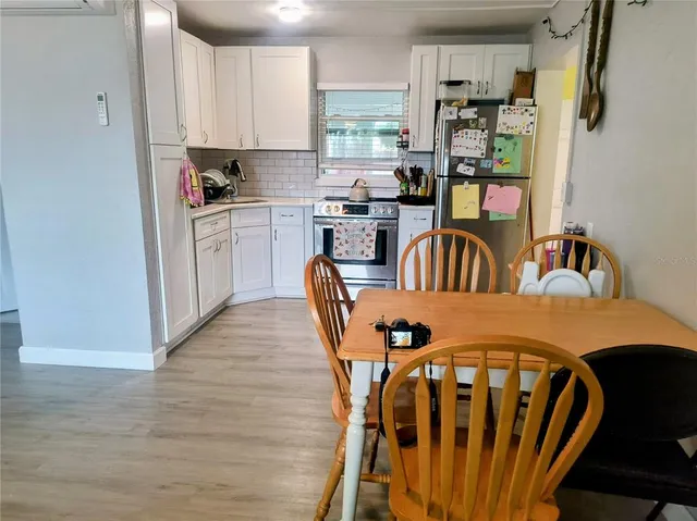 a kitchen with stainless steel appliances dining table chairs and a window