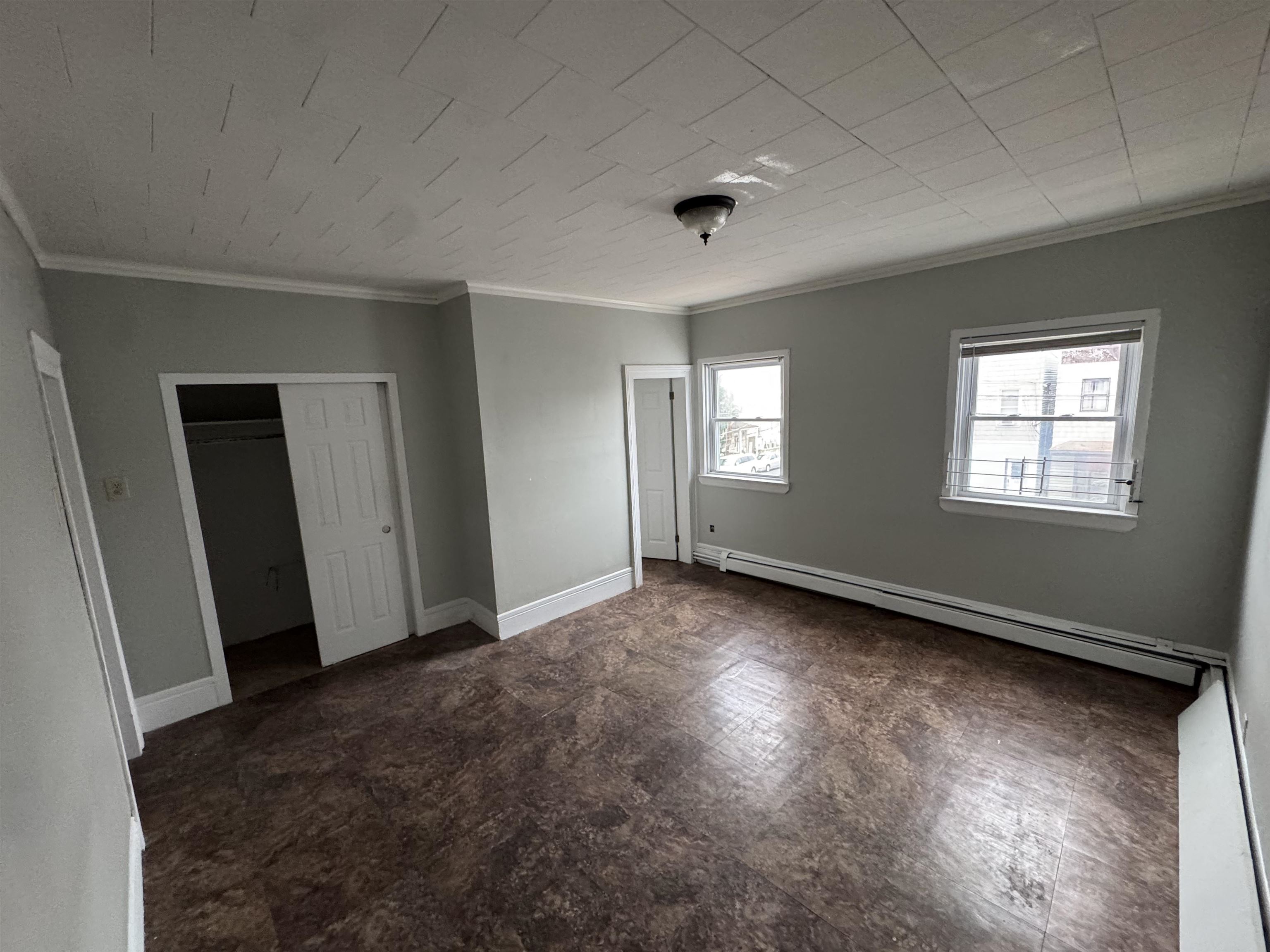 103 Prospect Avenue, Unit 2 Bayonne, NJ 07002 - Photo 7 of 12 a view of an empty room with wooden floor and windows