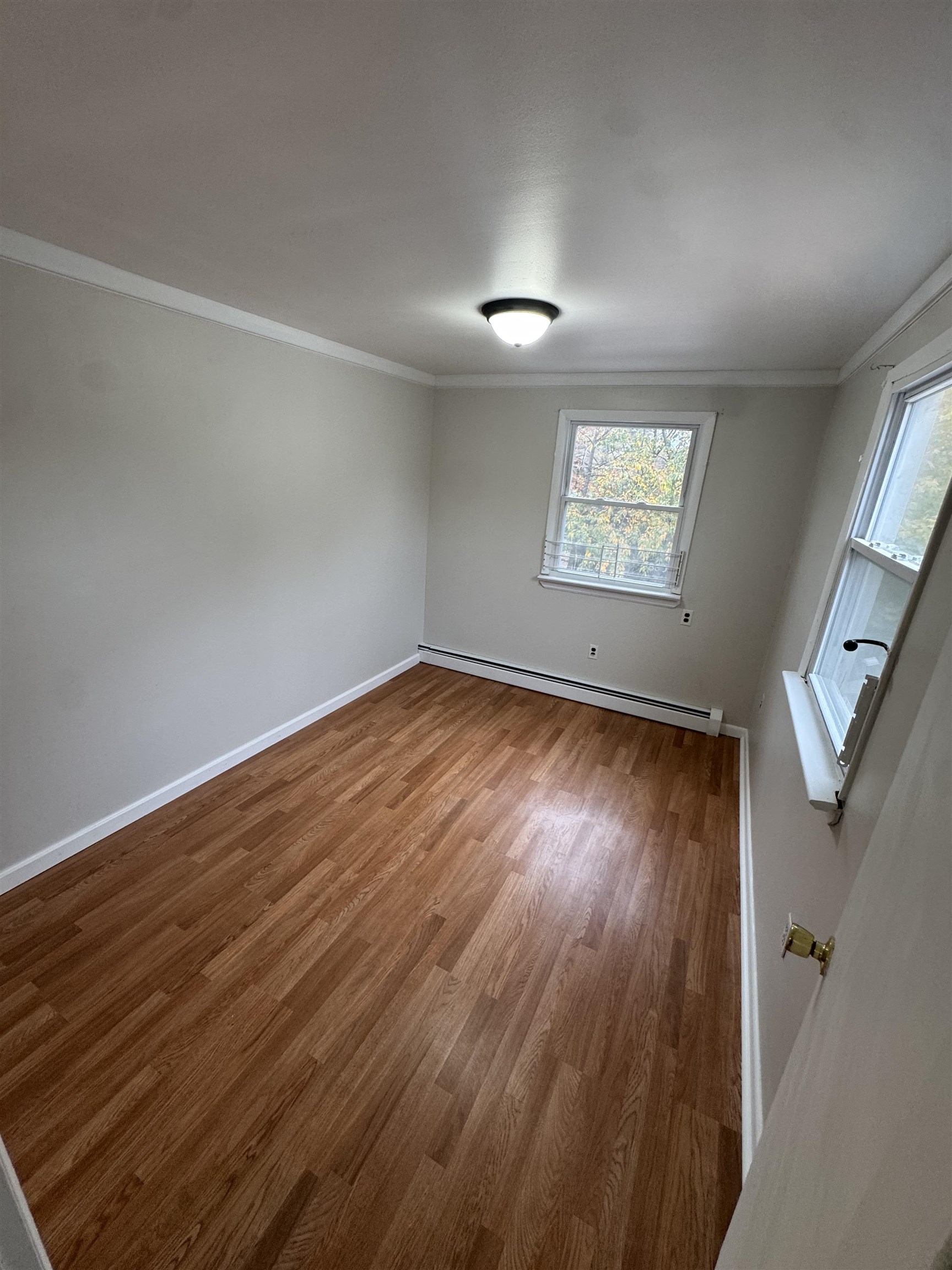 103 Prospect Avenue, Unit 2 Bayonne, NJ 07002 - Photo 8 of 12 an empty room with wooden floor and windows