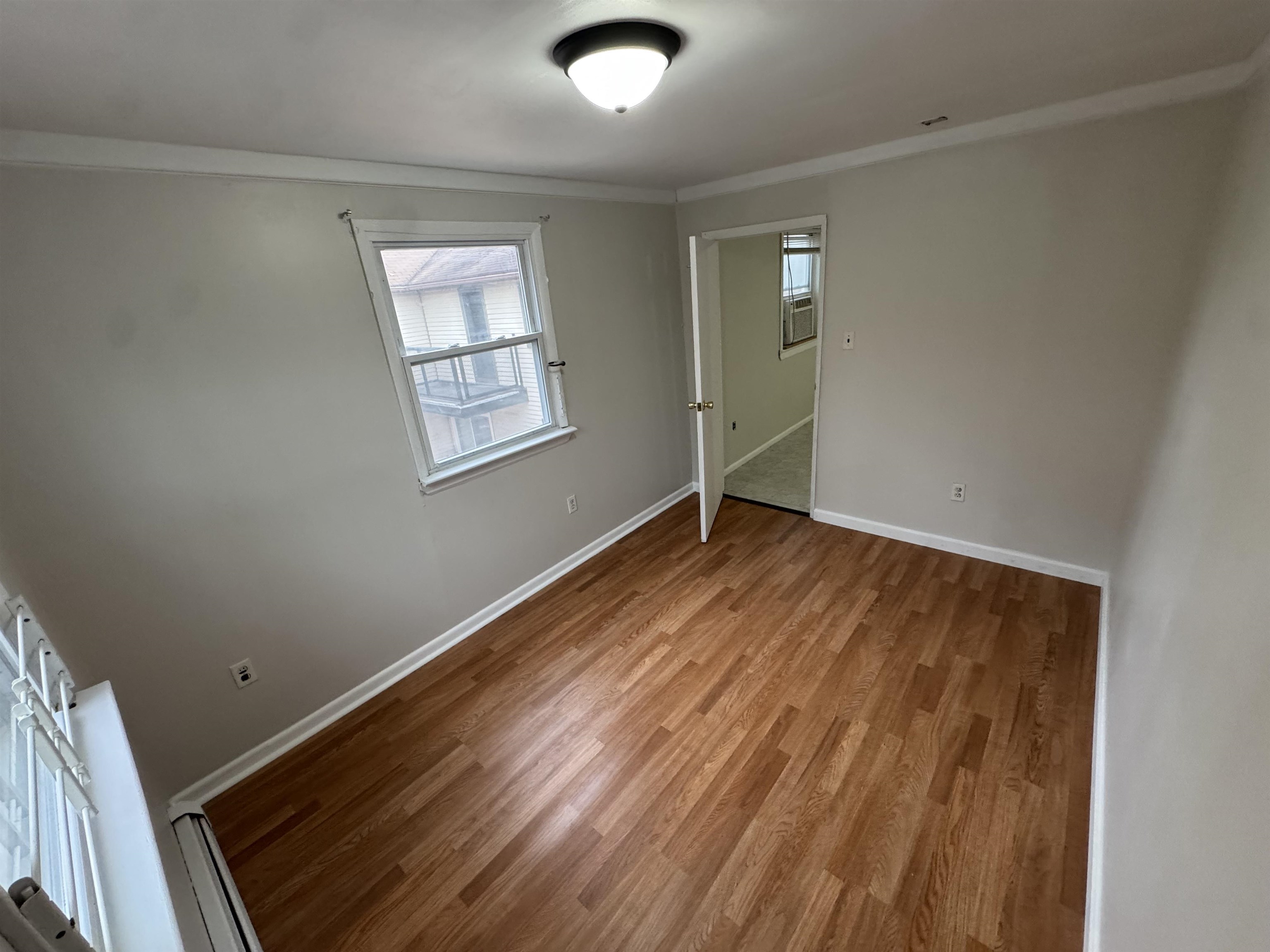 103 Prospect Avenue, Unit 2 Bayonne, NJ 07002 - Photo 9 of 12 an empty room with wooden floor and windows