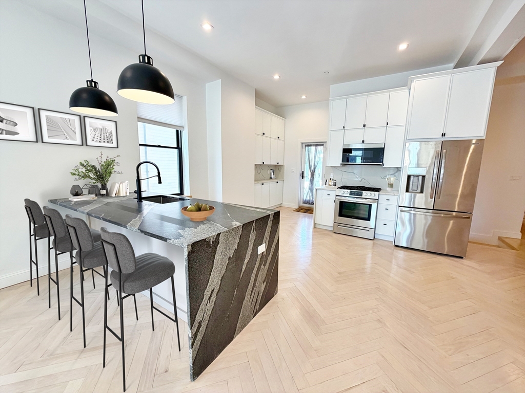 182 Webster Street, Unit 1 Boston, MA 02128 - Photo 2 of 41 a kitchen with stainless steel appliances granite countertop a stove a sink a refrigerator and a dining table with wooden floor