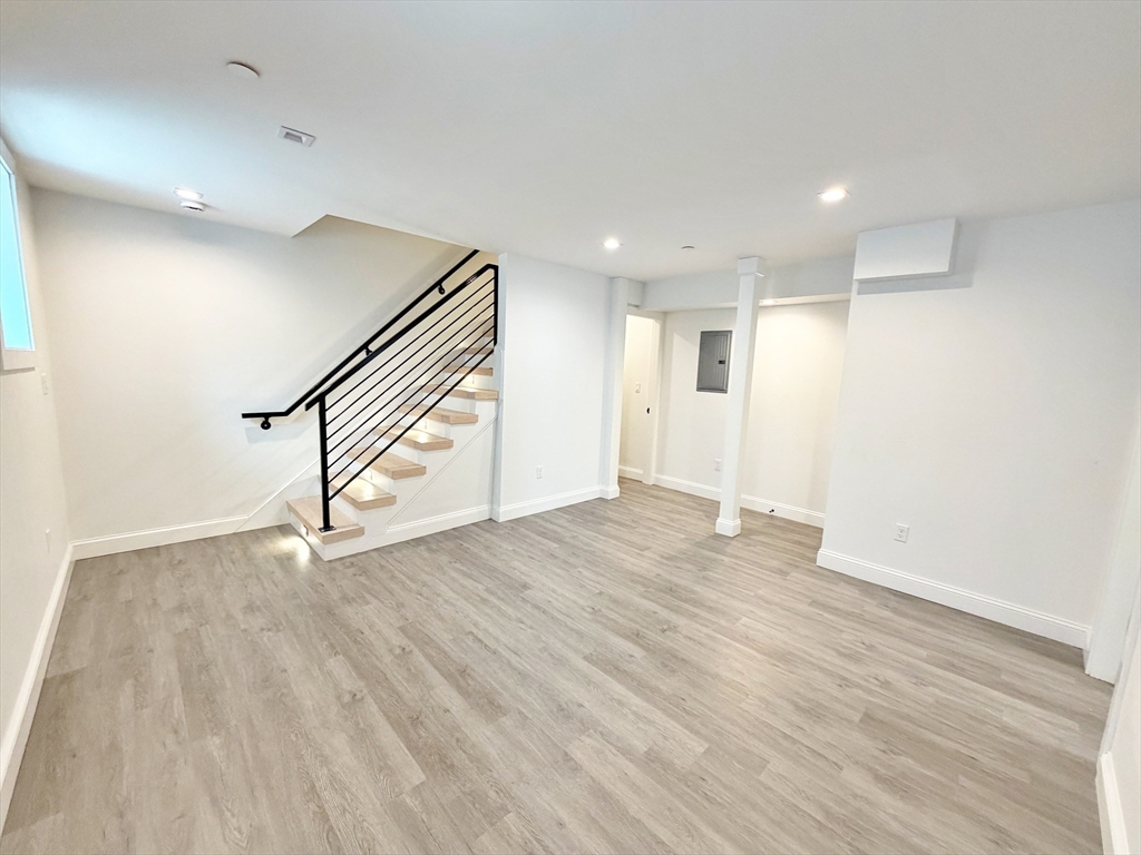 182 Webster Street, Unit 1 Boston, MA 02128 - Photo 29 of 41 a view of an empty room with wooden floor and stairs