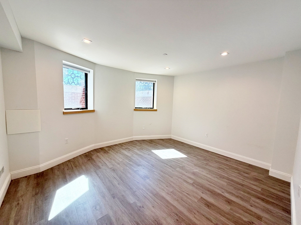 182 Webster Street, Unit 1 Boston, MA 02128 - Photo 32 of 41 a view of an empty room with wooden floor and a window