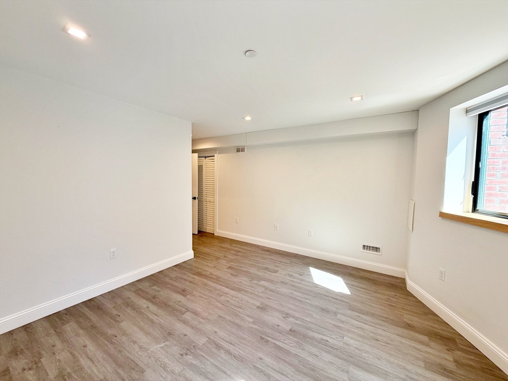 182 Webster Street, Unit 1 Boston, MA 02128 - Photo 34 of 41 a view of an empty room with wooden floor and a window