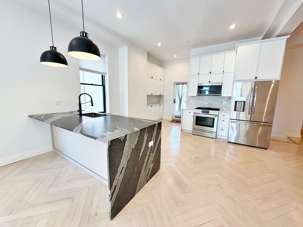 182 Webster Street, Unit 1 Boston, MA 02128 - Photo 10 of 41 a large kitchen with stainless steel appliances granite countertop a sink a stove and a refrigerator