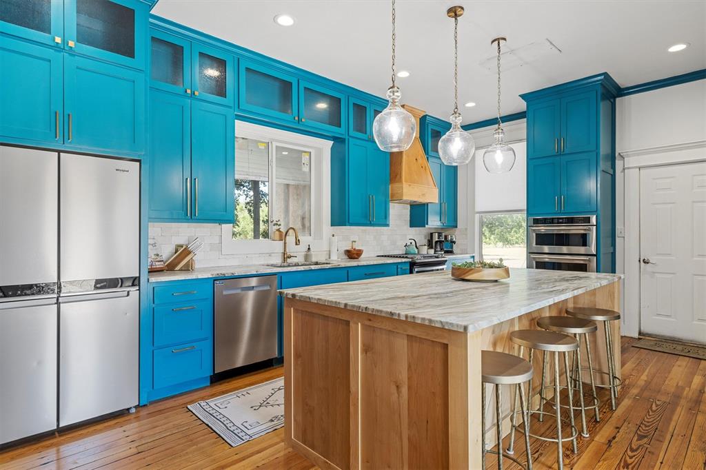 1004 South Old Temple Road Lorena, TX 76655 - Photo 11 of 40 Kitchen with a breakfast bar, appliances with stainless steel finishes, blue cabinetry, and a kitchen island