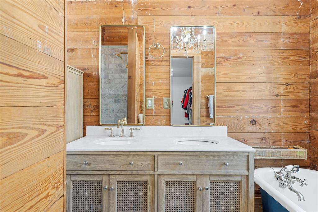 1004 South Old Temple Road Lorena, TX 76655 - Photo 17 of 40 Full bathroom with a freestanding bath, double vanity, wooden walls, and a sink