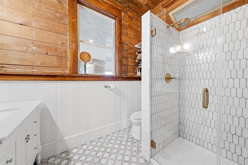 1004 South Old Temple Road Lorena, TX 76655 - Photo 22 of 40 Bathroom featuring a shower stall, vanity, toilet, wood walls, and tile patterned floors