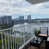 a view of a balcony with wooden chairs and wooden fence