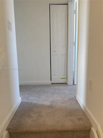 a view of a hallway with a wooden door