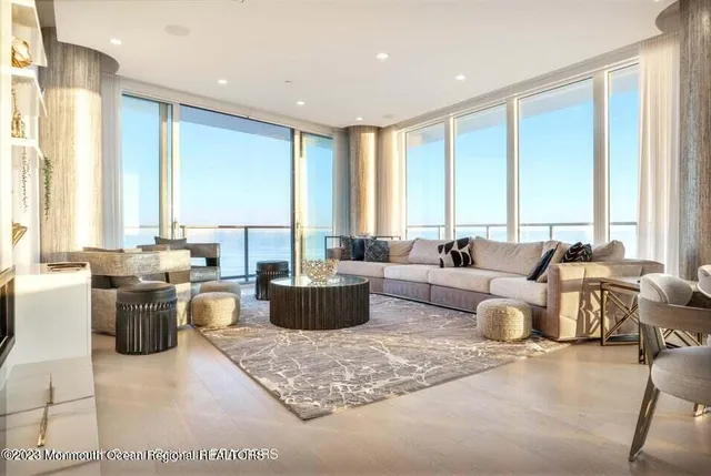 a living room with furniture and large windows