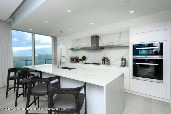 a kitchen with stainless steel appliances a table chairs and a refrigerator