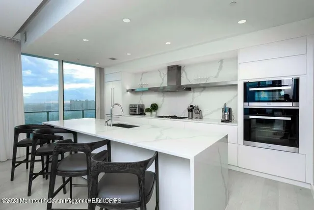 a kitchen with stainless steel appliances a table chairs and a refrigerator