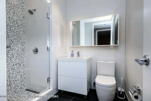 a bathroom with a toilet a sink and shower