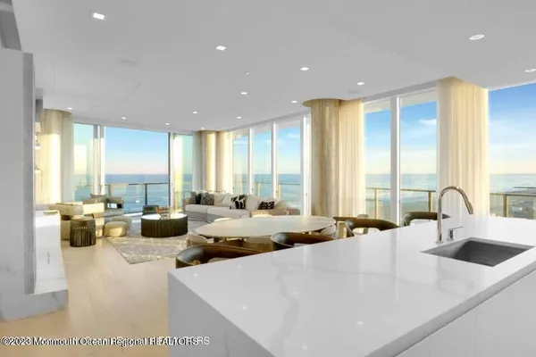 a large white kitchen with a large window and couch