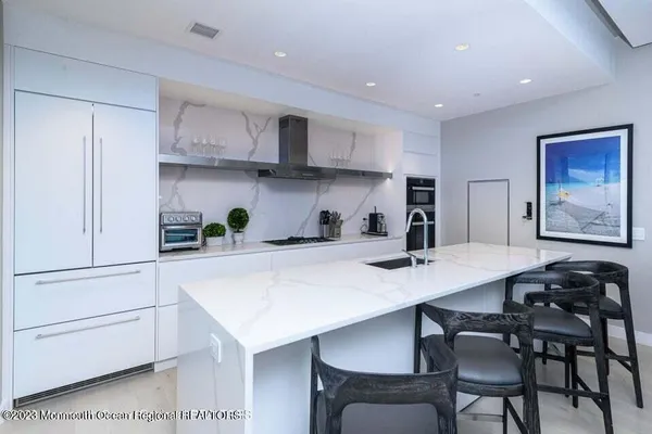 a kitchen with stainless steel appliances a table chairs and a refrigerator