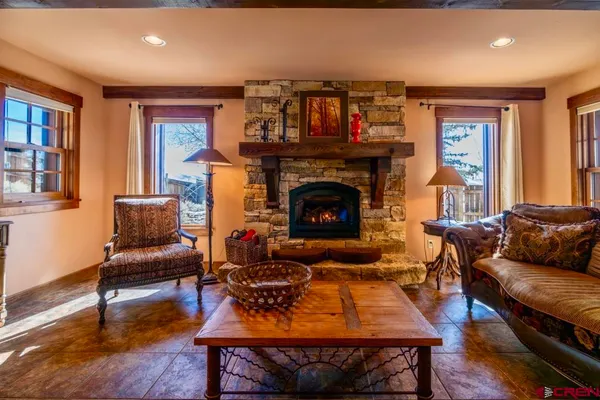 a bedroom with two beds and next to a window