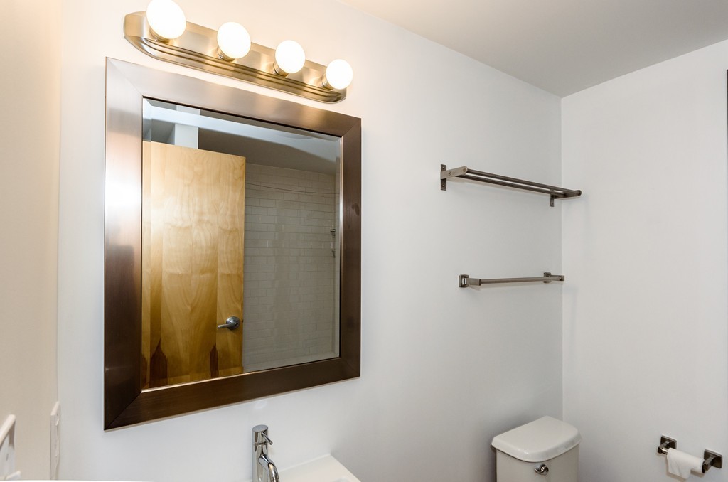 156 Porter Street, Unit 236 Boston, MA 02128 - Photo 8 of 16 a bathroom with a toilet and a mirror