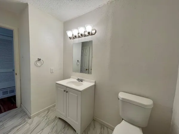 a bathroom with a toilet a sink and mirror
