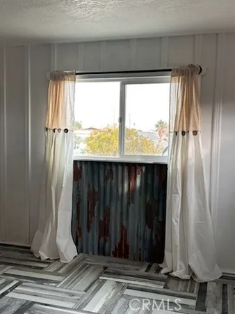 a view of a hallway with wooden floor and windows