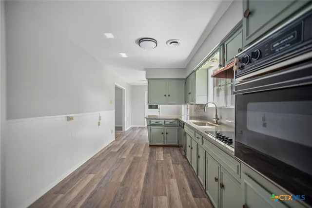a large kitchen with a lot of cabinets and stainless steel appliances