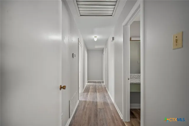 a view of a hallway with wooden floor