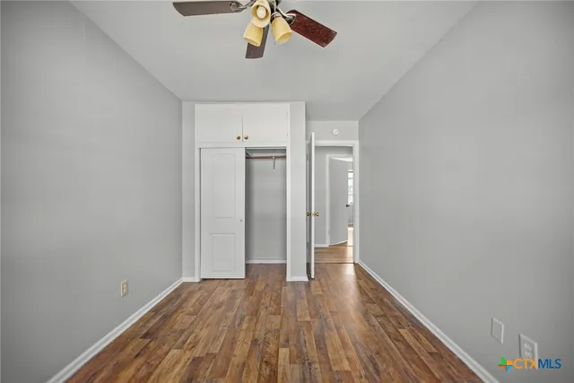 a view of a room with wooden floor and ceiling fan