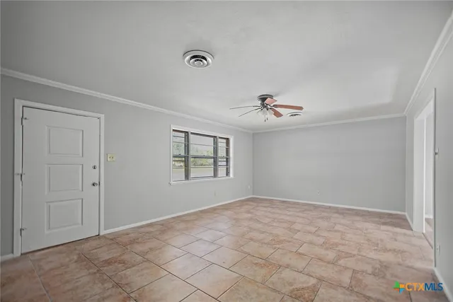 a view of a livingroom with a ceiling fan and window