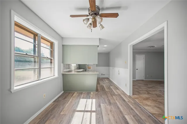 a view of a kitchen with wooden floor and a window