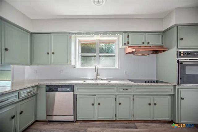 a kitchen with stainless steel appliances granite countertop a sink and a stove